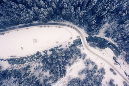Aerial view of a curved mountain road Aerial view of a curved mountain road in Europe. winter mountain landscape. Snow-covered trees and mountain slopes. Drone view.Europe.の写真素材
