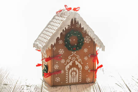 Gingerbread house on a white wooden table selective focus. New Year's gift.の写真素材