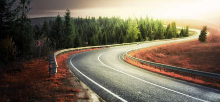 High quality road asphalt in the mountains. With markings and road infrastructure at sunset.の写真素材