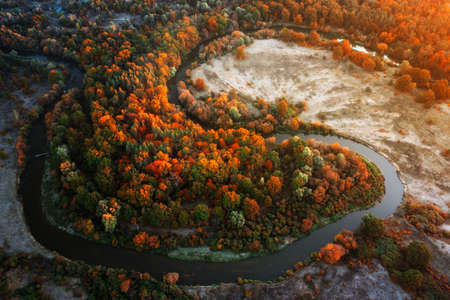 bright landscape. Winding river, floodplain, dry grass and autumn forest at dawn. environmentally friendly area.の写真素材