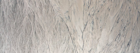 Traces of erosion on sand texture. top view