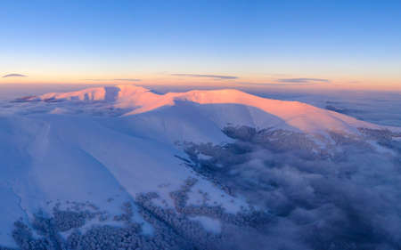 Snow-capped mountain peaks and coniferous forest. Wonderful winter forest in the mountains. mountain landscape.の写真素材