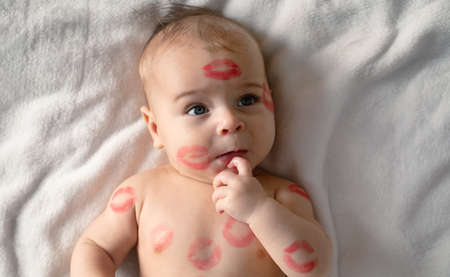 Cheerful baby with traces of kisses on the body. Valentine's day concept.の写真素材