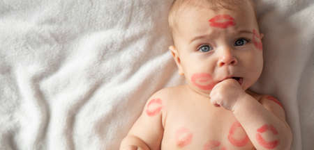 Cheerful baby with traces of kisses on the body. Valentine's day concept.の写真素材