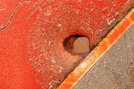 Bullet hole in old metal painted red. abstract background.の写真素材