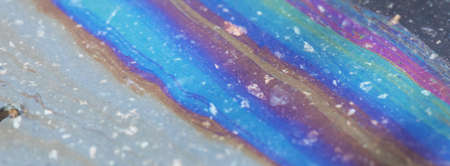 Bold multicolored spots on the asphalt. Water pollution by oil products.の写真素材