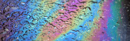 Bold multicolored spots on the asphalt. Water pollution by oil products.の写真素材