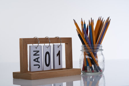 desk calendar and glass pencil holder against white backgrpoundの写真素材