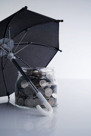 saving jar and umbrella against white backgroundの写真素材