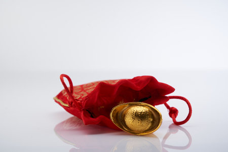 red chinese good luck bag with golden ingotsの写真素材
