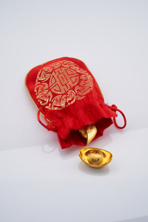red chinese good luck bag with golden ingotsの写真素材