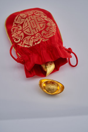 red chinese good luck bag with golden ingotsの写真素材
