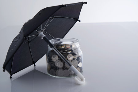 saving jar and umbrella against white backgroundの写真素材