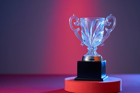 wining gold colored trophy on red purple backgroundの写真素材