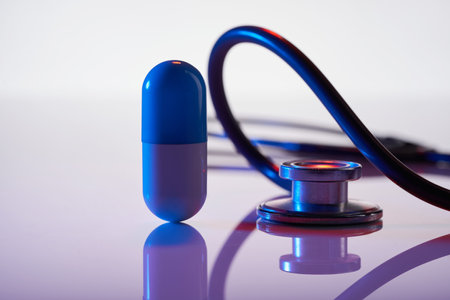 stethoscope and giant pill on white background with reflectionの写真素材