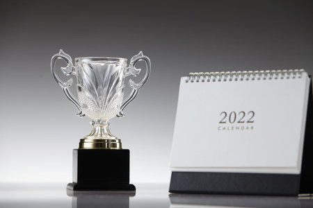 2022 desktop calendar and trophy on gray background