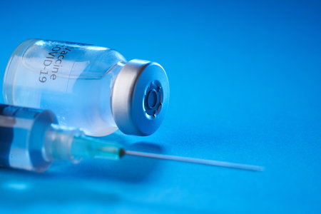 vaccine bottle on the blue backgroundの写真素材