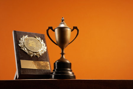 award trophy and plaque trophy against orange backgroundの写真素材