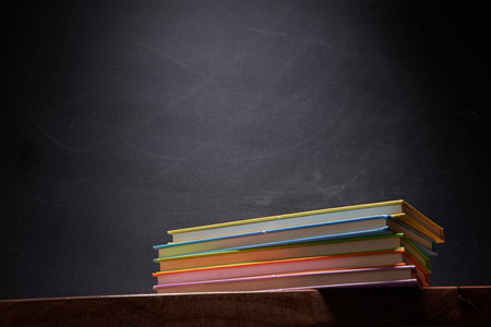 stack of book against blackboard with copy spaceの写真素材