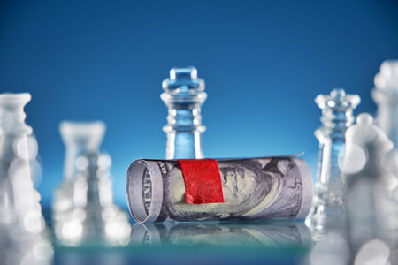 glass chess and 100 US currency with blind foldedの写真素材