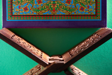 holly book koran with wooden stand against green backgroundの写真素材