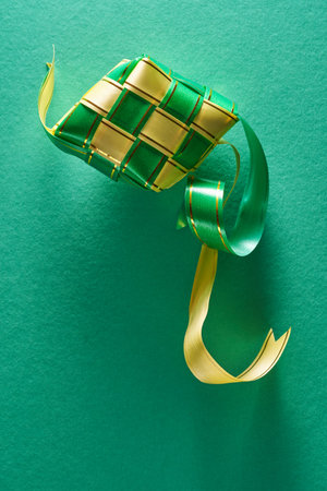 green yellow ketupat against green backgroundの写真素材
