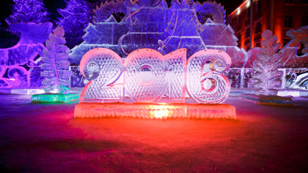 Happy new year 2016 written with ice letters, sculptures in the park with beautiful illumination at...
