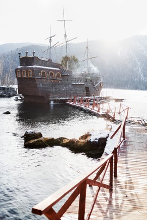 SAYANOGORSK, RUSSIA, DECEMBER 2014 - Entertainment boat for tourist trips, replica of the famous Black Pearl from the movie Pirates of the Caribbean docked in the bay of Yenisey River, South Siberia.のeditorial素材