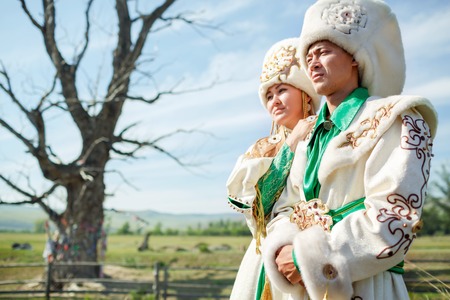 Couple in traditional dress, on a background of epic ancient tree in the middle of the rural landscape.の写真素材