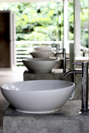 White wash basin with combination faucet is made from silver metal.の写真素材