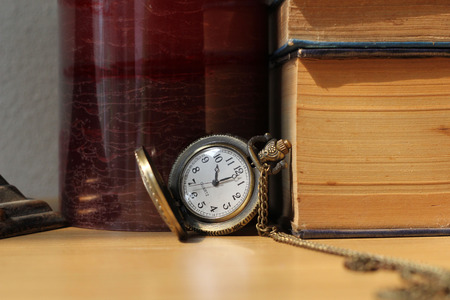 Books on antique clocks on the desk in vintage style.の写真素材