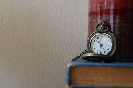 Books on antique clocks on the desk in vintage style.