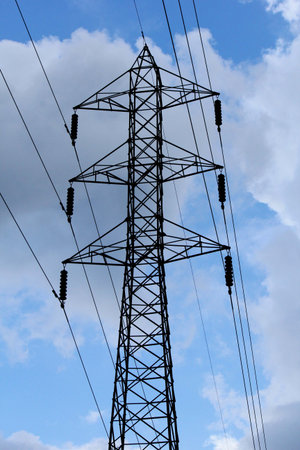 Electricity pole with a background of sky and bright clouds.