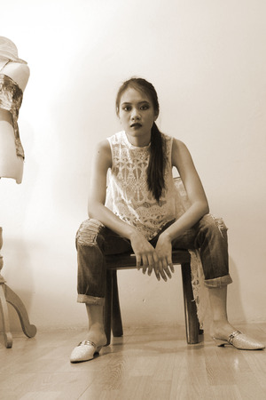 Fashion shoot girl sitting on a wooden chair in an old house Retro style photoの写真素材