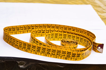 Yellow dressmaker's tape measure for clothing and its derivatives