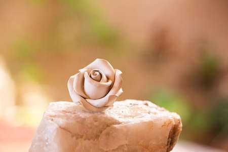 Unfinished artisan rose flower meticulously handcrafted on a very blurred backgroundの写真素材