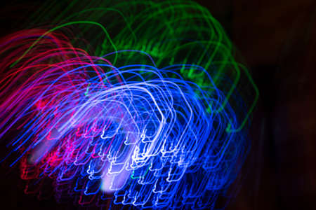 Colorful psychedelic lights and shadows in a dazzling stream of diverse lightの写真素材