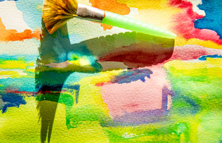 Paintbrush with color paint on a colorful watercolor background.の写真素材