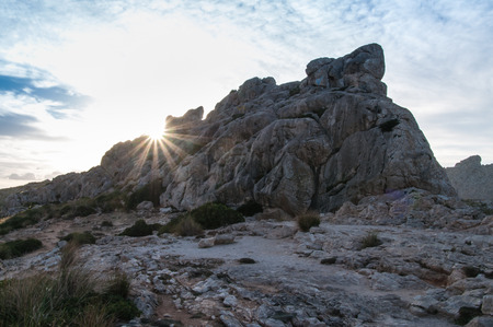 Sun beams behind a mountain at Mallorca, Spain, at twilightの写真素材