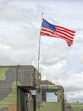 US flag waves at a military vehicleの写真素材
