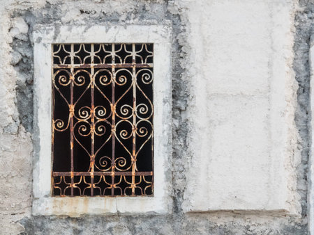 window with ornated iron bars in a white building in Croatia