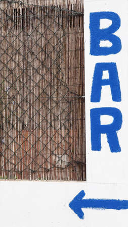 Sign which shows in blue lettering the way to a barの写真素材
