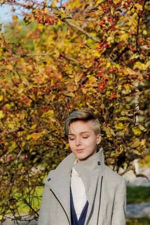 Modern girl with colored short hair in autumnの写真素材