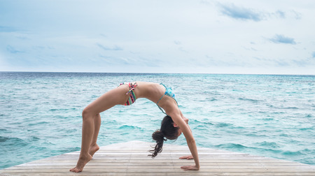 yoga on clear blue ocean in maldivesの写真素材