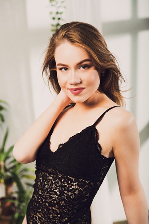 Portrait of beautiful young brunette woman posing in black lingerie body at sunriseの写真素材