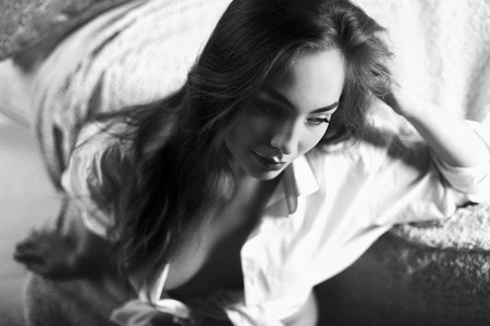 Black and white portrait of very beautiful young woman in unbuttoned man's shirtの写真素材