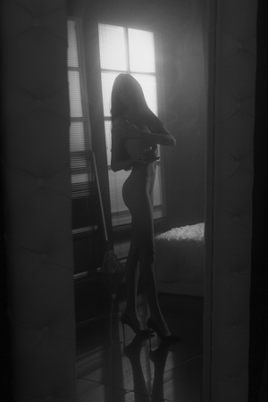 Beautiful young woman in a image of witch standing naked or nude in a mirror holding a magick cream prepearing to Helloween part as Margarita from Master and Margarita.の写真素材