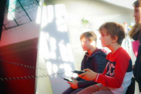 Blur picture of children playing game with remote deviceの写真素材