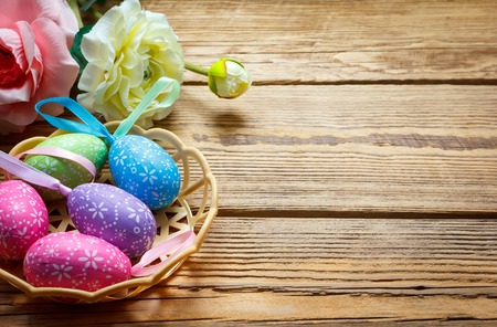 Easter eggs in the basket of wooden boards