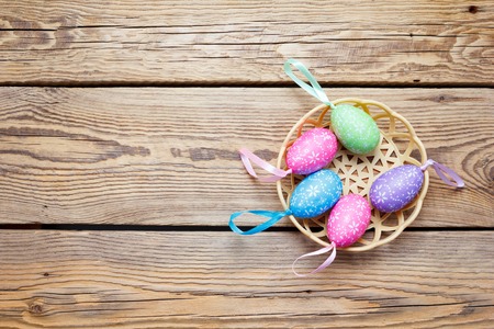 Easter eggs in the basket of wooden boards
